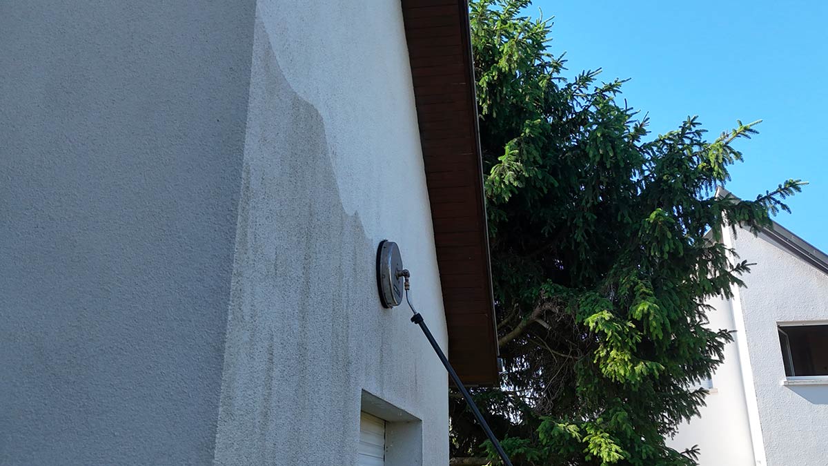 Façade de maison noircie en Alsace avant nettoyage vapeur, traces noires de pollution et d'algues